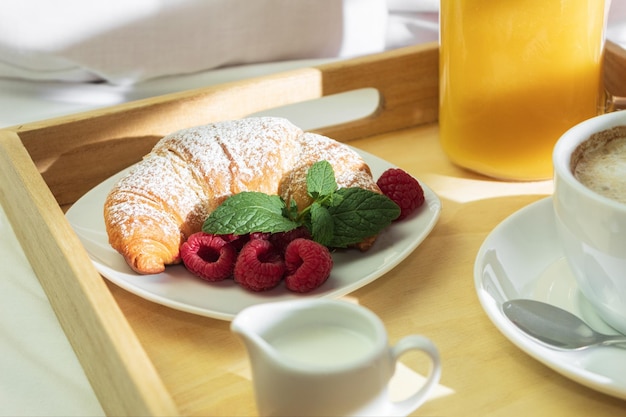 Jugo de naranja de café y un croissant en un tallo de madera