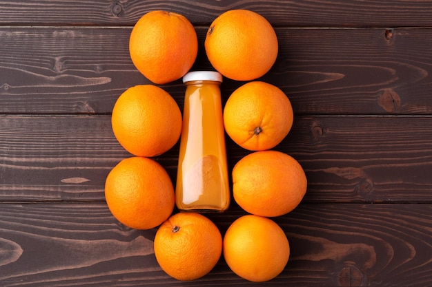 Jugo de naranja fresco en el vaso con fruta naranja sobre fondo de madera