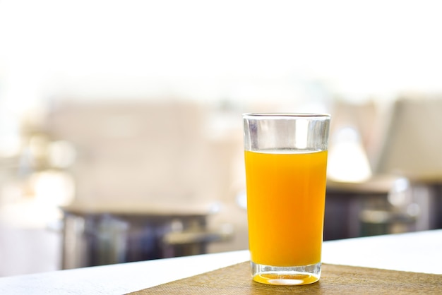 Jugo de naranja fresco en un vaso sobre la mesa.