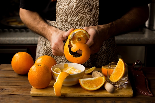 El jugo de naranja hecho con el hombre en una mesa de madera.