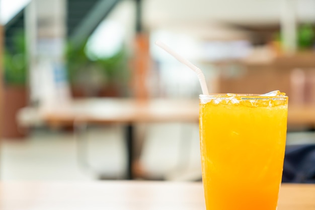 Jugo de naranja helado en la mesa de madera en la cafetería restaurante