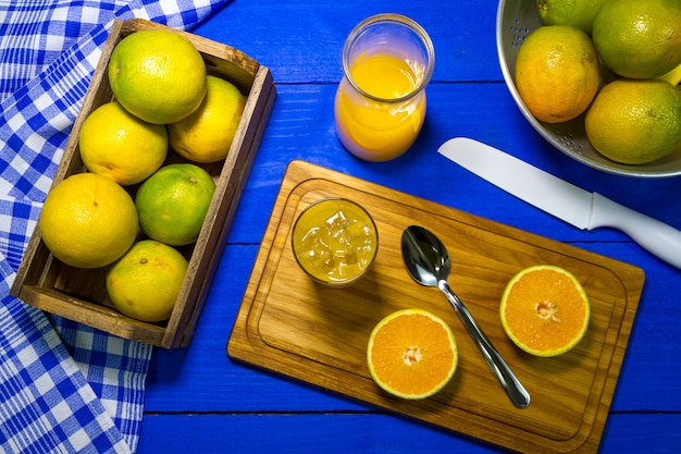 Jugo de naranja en la mesa en color azul.