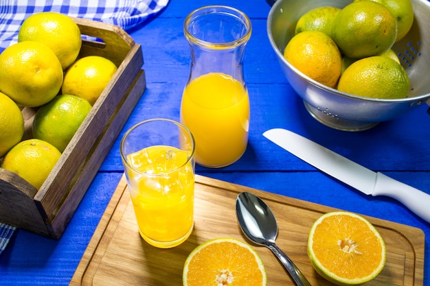 Jugo de naranja en la mesa en color azul.