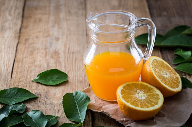 Jugo de naranja y naranja con hojas verdes