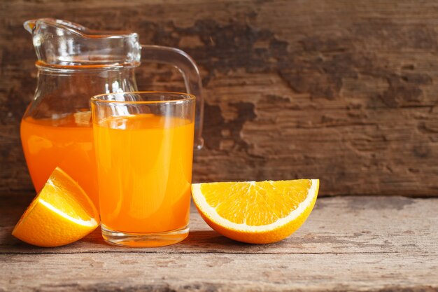 Foto jugo de naranja y naranja sobre fondo de madera