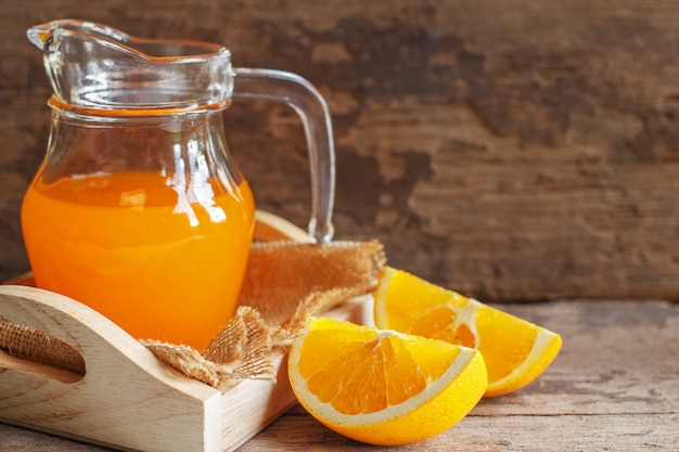 Jugo de naranja y naranja sobre fondo de madera