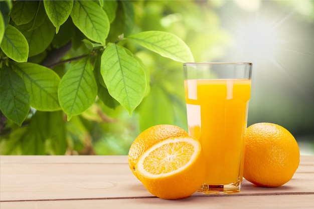 Jugo de naranja y rodajas de naranja sobre fondo