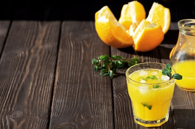 Jugo de naranja en el vaso con hojas de menta