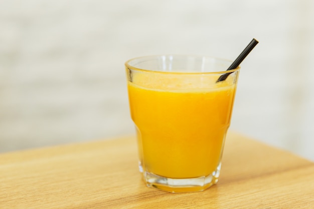 Jugo de naranja en un vaso en la mesa de madera en un restaurante