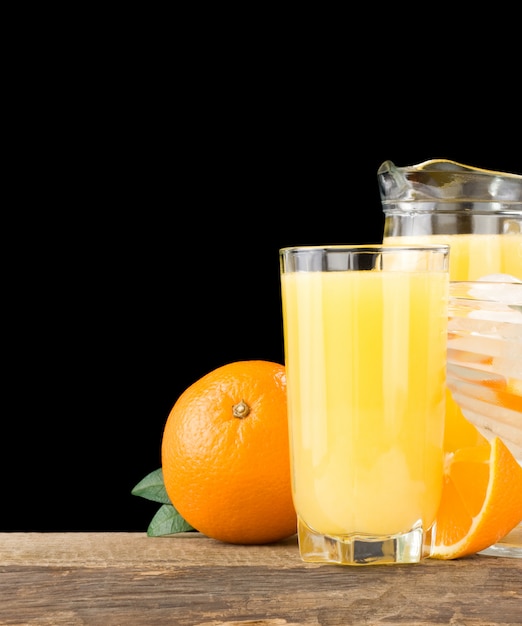 Jugo de naranja en vaso y taza cerca de fruta naranja