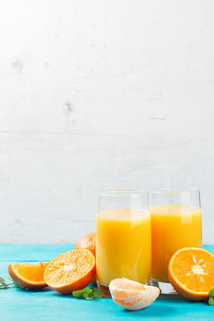 Jugo de naranja en vasos y naranjas