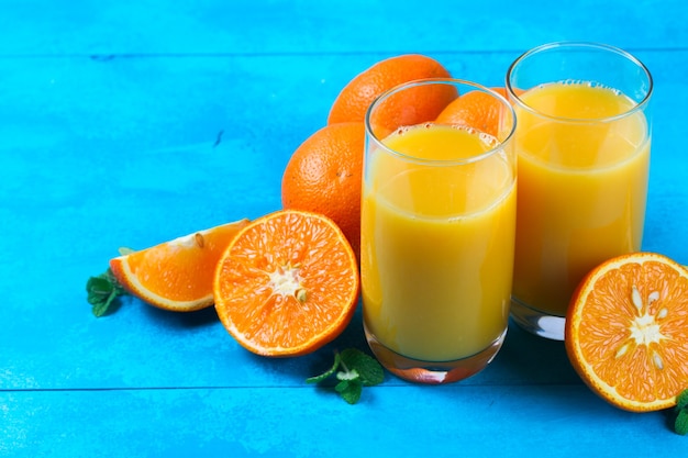 Jugo de naranja en vasos y naranjas