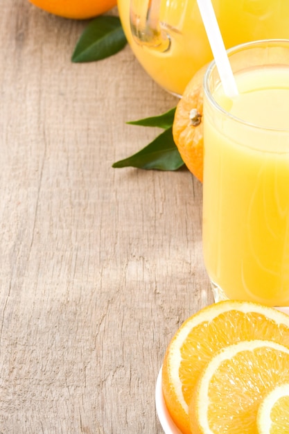 Jugo de naranja y vidrio sobre fondo de madera