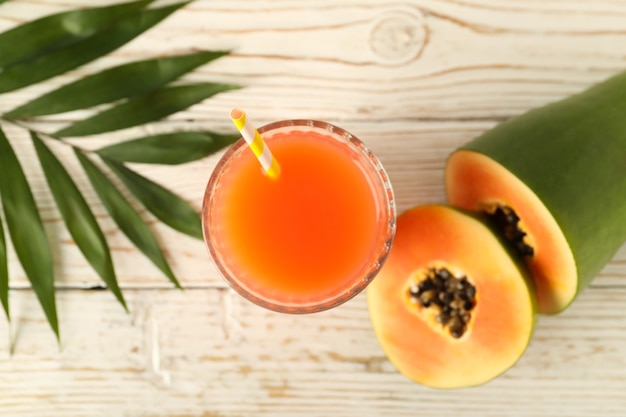 Jugo de papaya fresca en mesa de madera blanca