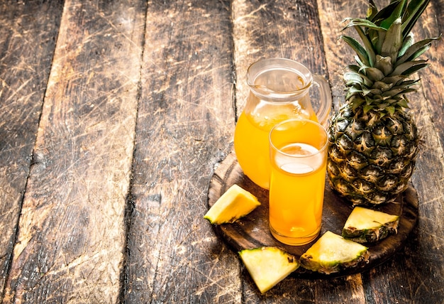 Jugo de piña fresca en mesa de madera.