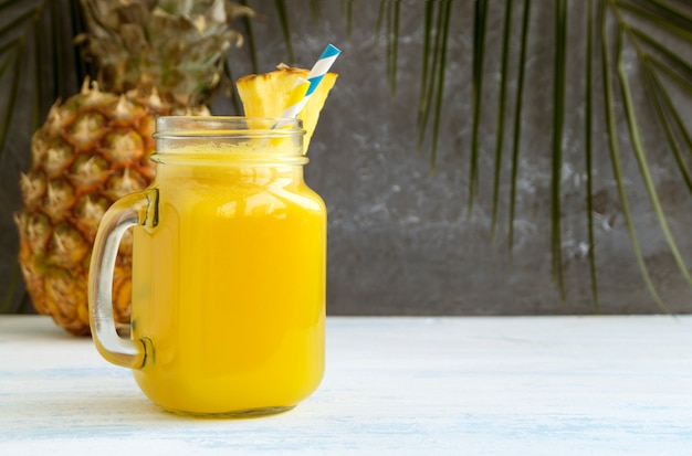 Jugo de piña en un tarro con una pajita.