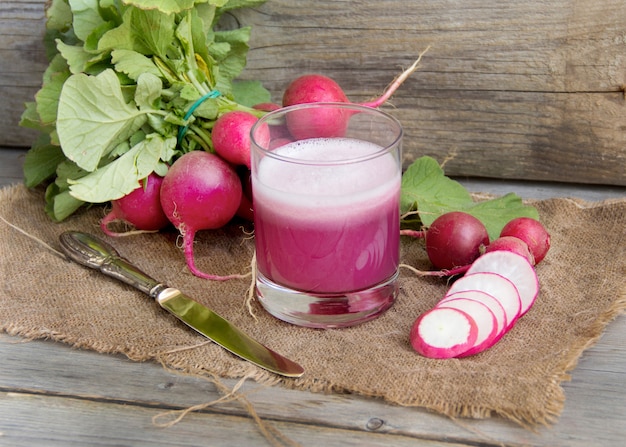 Jugo de rábano fresco en el vaso sobre una mesa de madera de cerca