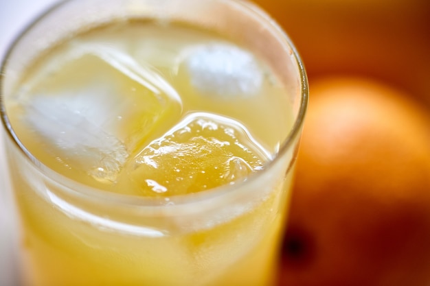 Foto jugo recién exprimido en un vaso con primer plano de hielo