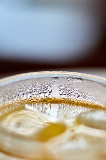 Jugo recién exprimido en un vaso con primer plano de hielo