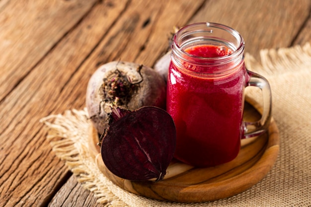 Jugo de remolacha roja en un vaso sobre la mesa de madera