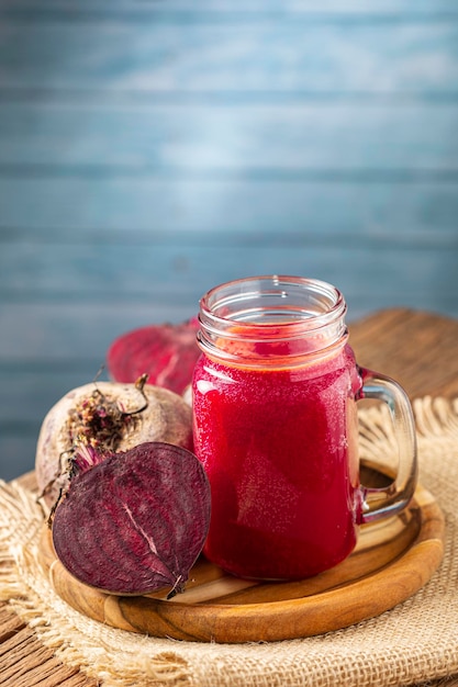 Jugo de remolacha roja en un vaso sobre la mesa de madera