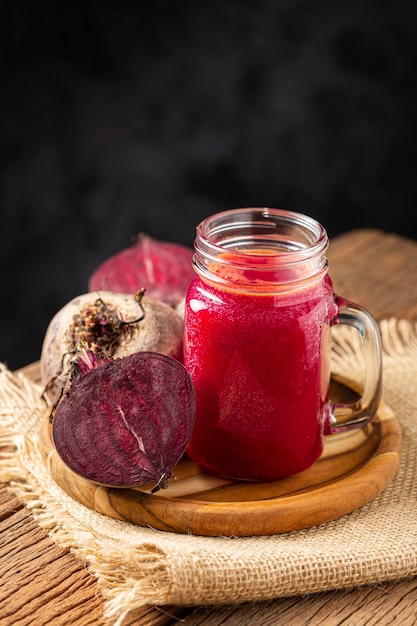 Jugo de remolacha roja en un vaso sobre la mesa de madera