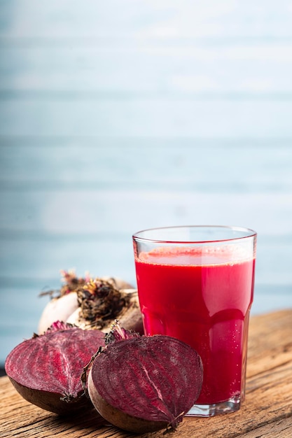 Jugo de remolacha roja en un vaso sobre la mesa de madera