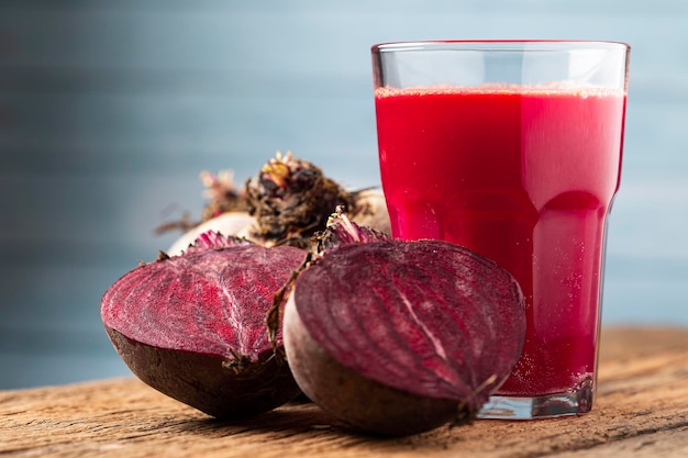 Jugo de remolacha roja en un vaso sobre la mesa de madera