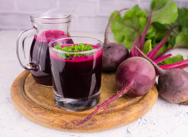 Jugo de remolacha en un vaso y una jarra en el fondo Concepto de bebidas de desintoxicación