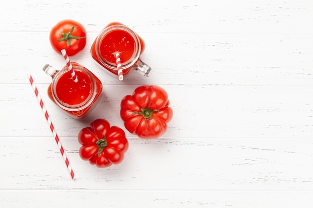 Jugo de tomate fresco y tomates maduros