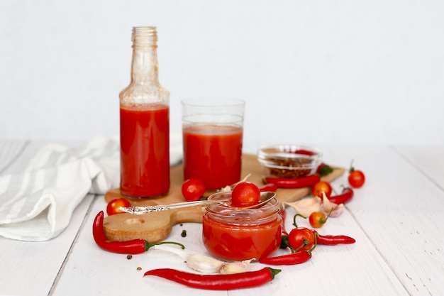 Jugo de tomate fresco y tomates en una tabla para cortar madera