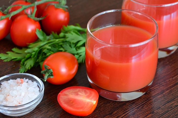 jugo de tomate fresco en vaso decorado con tomates cherry, sal y perejil