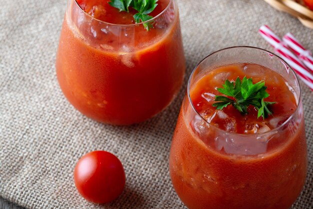 Jugo de tomate con hielo en un vaso de perejil y tomate en saqueo