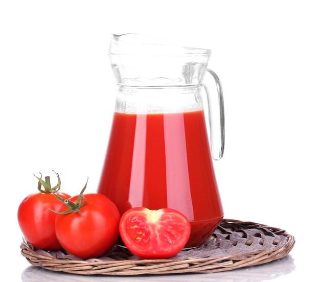 Jugo de tomate en jarra sobre estera de mimbre aislado en blanco