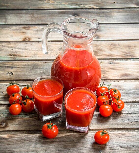 Jugo de tomate en una jarra y tomates frescos