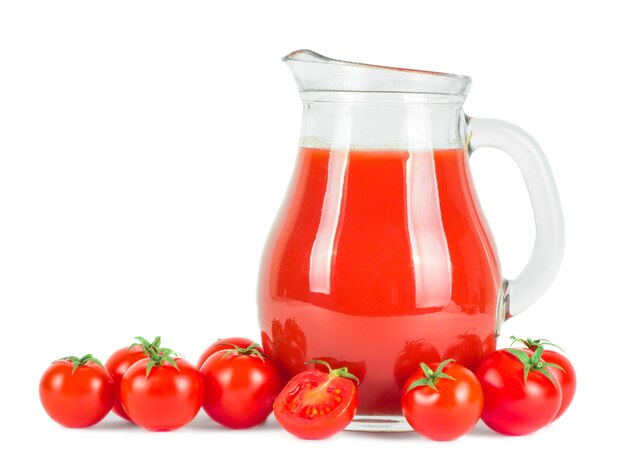 Jugo de tomate en jarra y tomates frescos