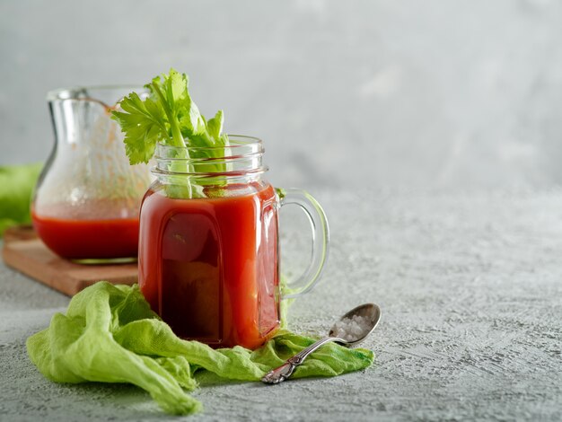 Jugo de tomate en tarro de albañil con apio y sal,