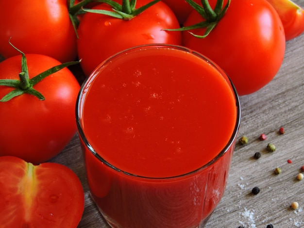 Foto jugo de tomate, tomates frescos y especias.