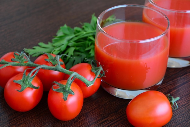 jugo de tomate con tomates y tazón de sal sobre fondo de madera oscura