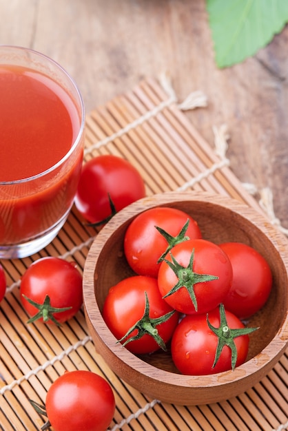 Jugo de tomate. Vaso de jugo de tomate con verduras sobre fondo de madera