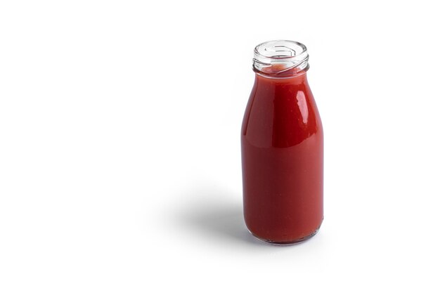 Jugo de tomate en vidrio aislado en blanco.