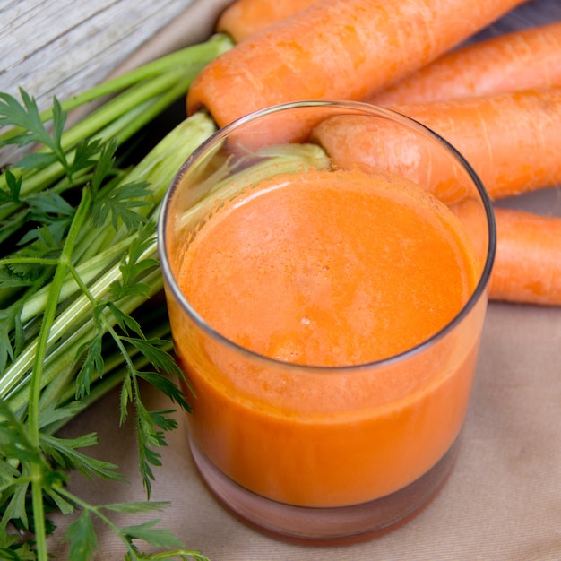 Jugo de zanahoria fresco en una mesa de madera