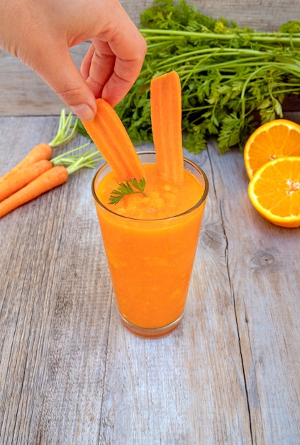 jugo de zanahoria en vidrio en mesa de madera