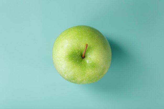 Jugosa manzana verde sobre fondo verde con una composición minimalista.