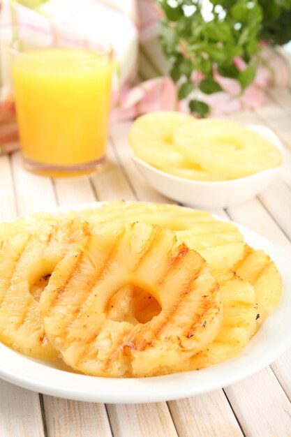 Jugosa piña a la parrilla en un plato en el primer plano de la mesa