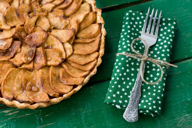 Jugosa tarta de manzana con canela y brandy sobre una mesa verde