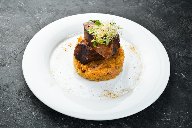 Jugosas costillas de cerdo al horno con col estofada en un plato Vista superior