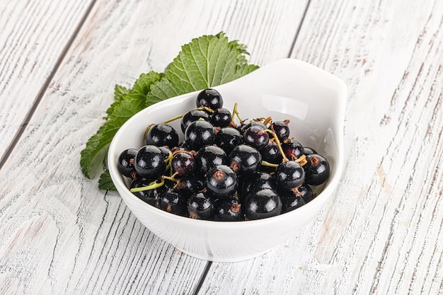 Jugosas y dulces bayas de grosella negra en el cuenco