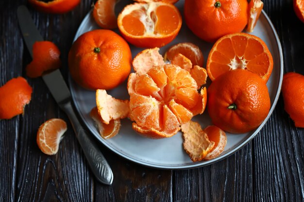 Jugosas mandarinas maduras en un plato Pelar una mandarina Pieles de cítricos