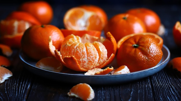 Jugosas mandarinas maduras en un plato Pelar una mandarina Pieles de cítricos